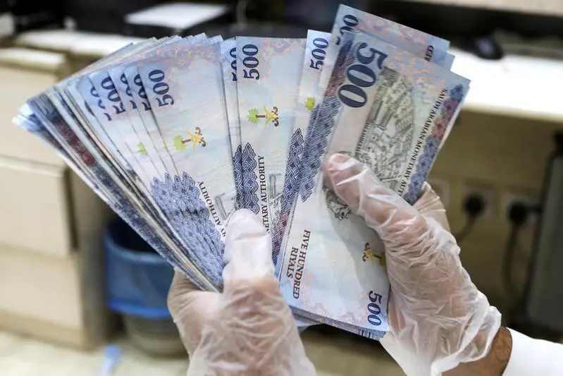 A Saudi money exchanger wears gloves as he counts Saudi riyal currency at a currency exchange shop in Riyadh, Saudi Arabia March 10, 2020. Image used for illustrative purpose , Reuters Images/Ahmed Yosri 
