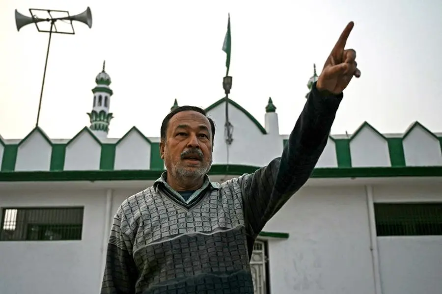 This photograph taken on December 28, 2023 shows Mohammed Shahid, 52, an aggrieved Muslim who lost his father and uncle to the 1992 religious riots in Ayodhya, gesture in front of a mosque during an interview with AFP. For many Indians the opening of a grand new temple in Ayodhya on January 2024 is a long-held dream come true but for Muslims like Mohammed Shahid, the day will evoke only blood-soaked memories. (Photo by Arun SANKAR / AFP) / To go with 'INDIA-RELIGION-POLITICS-UNREST� FOCUS by Abhaya SRIVASTAVA