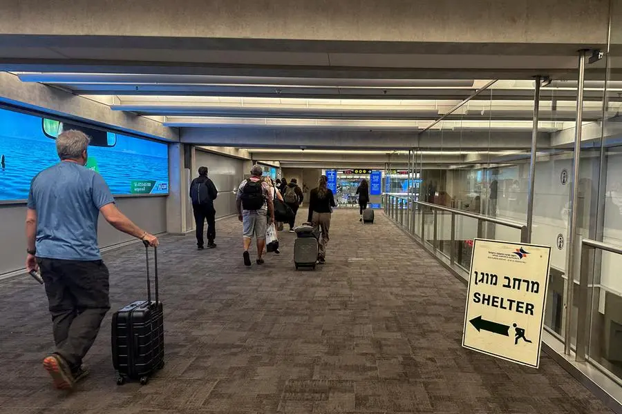 People walk next to a sign directing for Shelter after landing in Israel at the arrivals section of Ben Gurion International airport in Lod near Tel Aviv, Israel October 11, 2023 REUTERS/Marius Bosch , Reuters/REUTERS