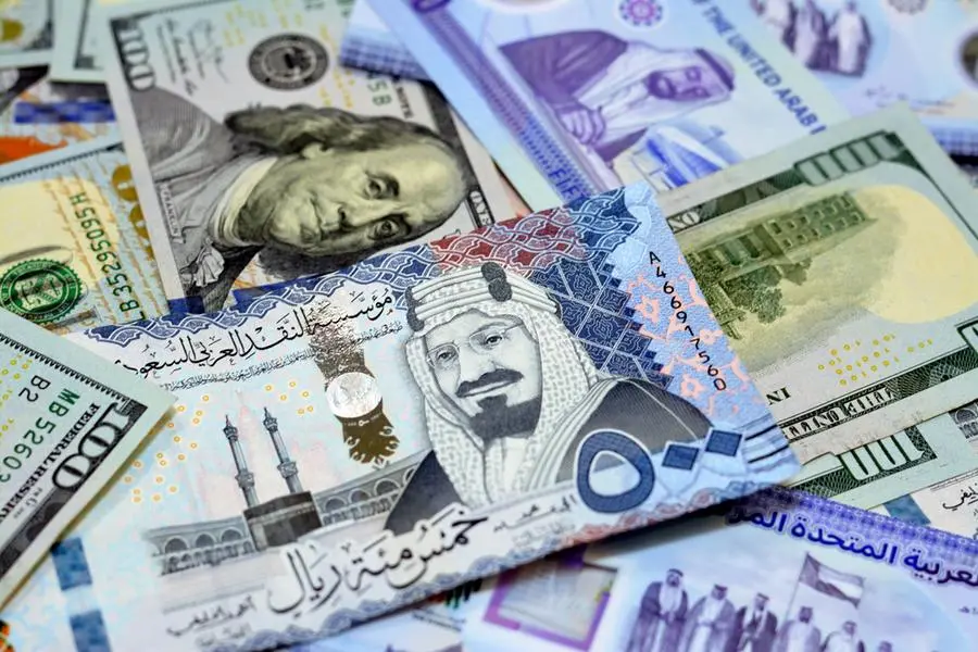 Pile of American dollar bills American cash money banknotes with Saudi Arabia riyals money banknotes. Image used for illustrative purpose. Getty Images