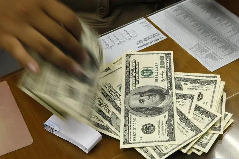 Image for illustrative purpose. A money changer holds stacks of US dollar notes in Jakarta, August 29, 2013. Beawiharta Beawiharta, Reuters , Reuters Images