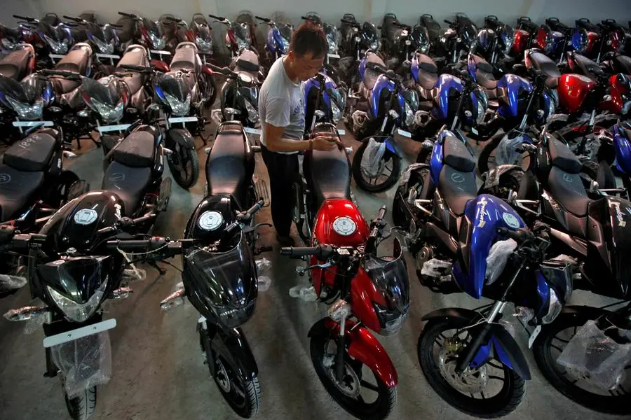 FILE PHOTO: FILE PHOTO: A worker cleans a Bajaj motorcycle at a Bajaj showroom in Kolkata October 16, 2013. REUTERS/Rupak De Chowdhuri/File Photo , Reuters