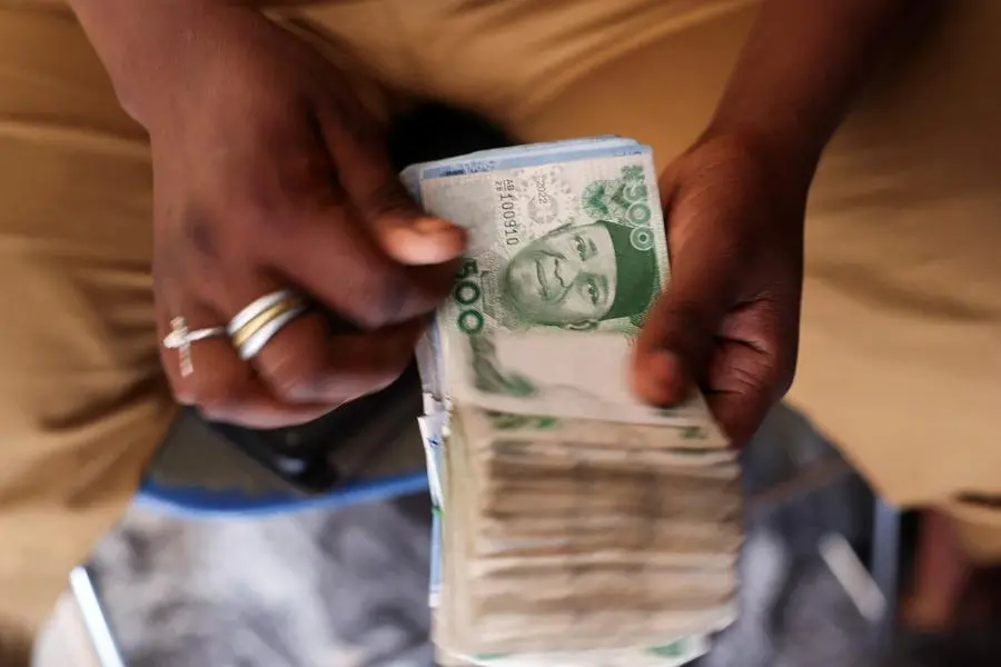 FILE PHOTO: A man counts Nigerian naira notes in a market place as people struggle with the economic hardship and cashflow problems ahead of Nigeria\\'s Presidential elections, in Yola, Nigeria, February 22, 2023. REUTERS/Esa Alexander/File Photo Image for illustrative purpose. , Reuters/REUTERS