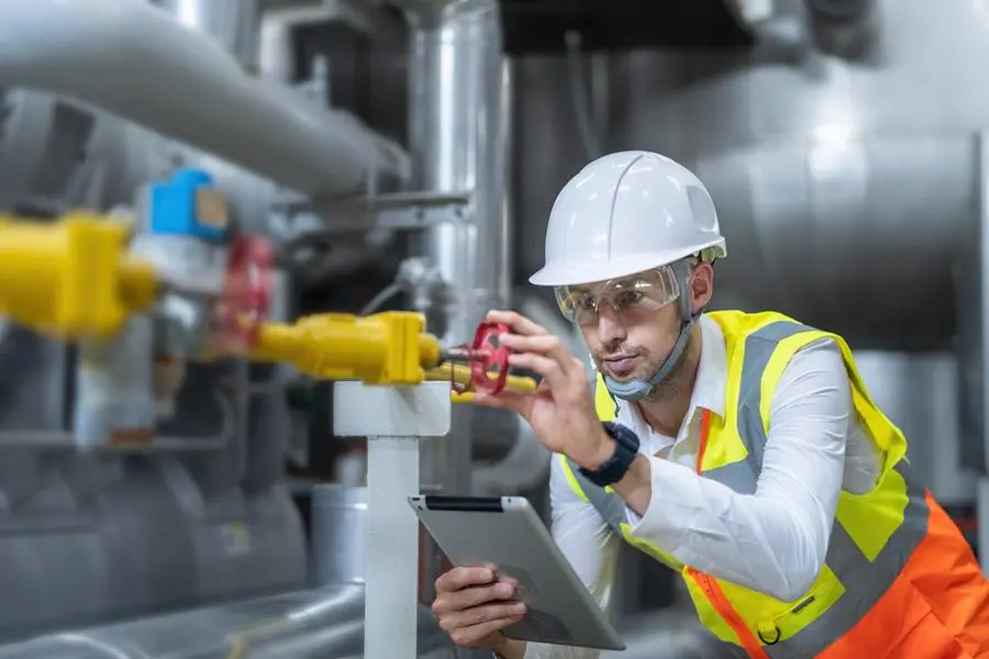 Technician engineer working in industrial plant by checking valve pipe, operation engineer working in industrial plant with tablet. Getty Images Image used for illustrative purpose. , Getty Images