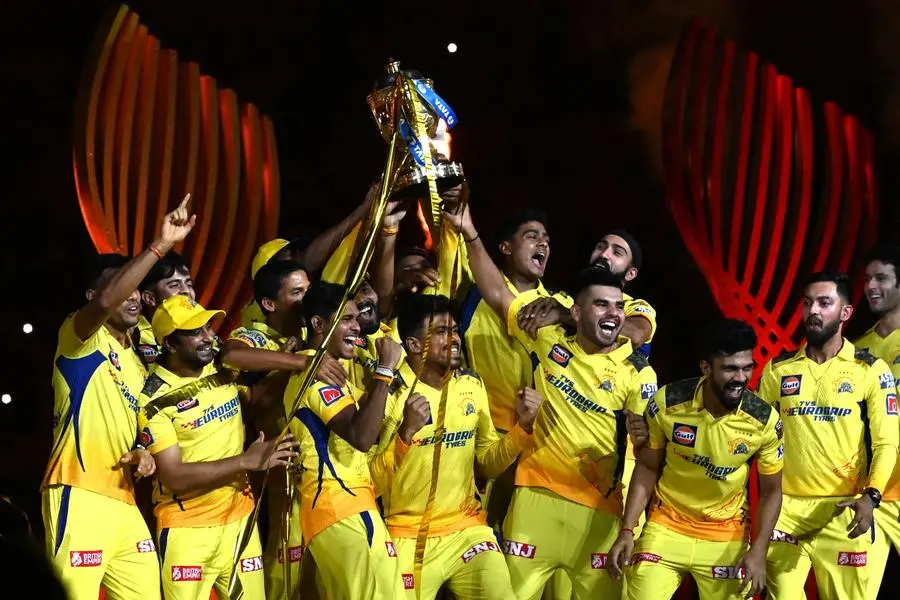 Chennai Super Kings' players celebrate with the trophy after their victory against Gujarat Titans in the Indian Premier League (IPL) Twenty20 final cricket match at the Narendra Modi Stadium in Ahmedabad on May 30, 2023. (Photo by Sajjad HUSSAIN / AFP)