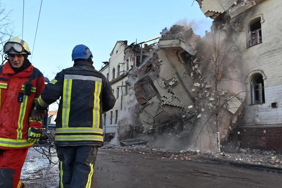 TOPSHOT - Ukrainian rescuers supervise the dismantling of a residential building partially destroyed as a result of a missile attack in Kharkiv on January 17, 2024. At least 17 people were wounded in Russian strikes on residential buildings in the city centre on January 16, 2024, the regional governor said. (Photo by SERGEY BOBOK / AFP) , Agence France-Presse (AFP)/AFP