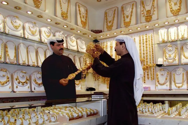 A Kuwaiti gold shop seller shows a gold head jewel to a customer at the gold market in Kuwait city December 23. , Reuters Images/Yves Herman