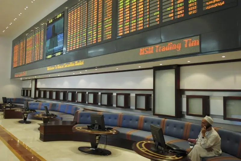 An investor talks on his mobile phone, whilst working on his computer, on the trading floor of the Muscat Securities Market (MSM) in the Commercial Business District of Ruwi in Muscat, October 2, 2007. Stringer, Reuters Image used for illustration purpose. , Reuters Images