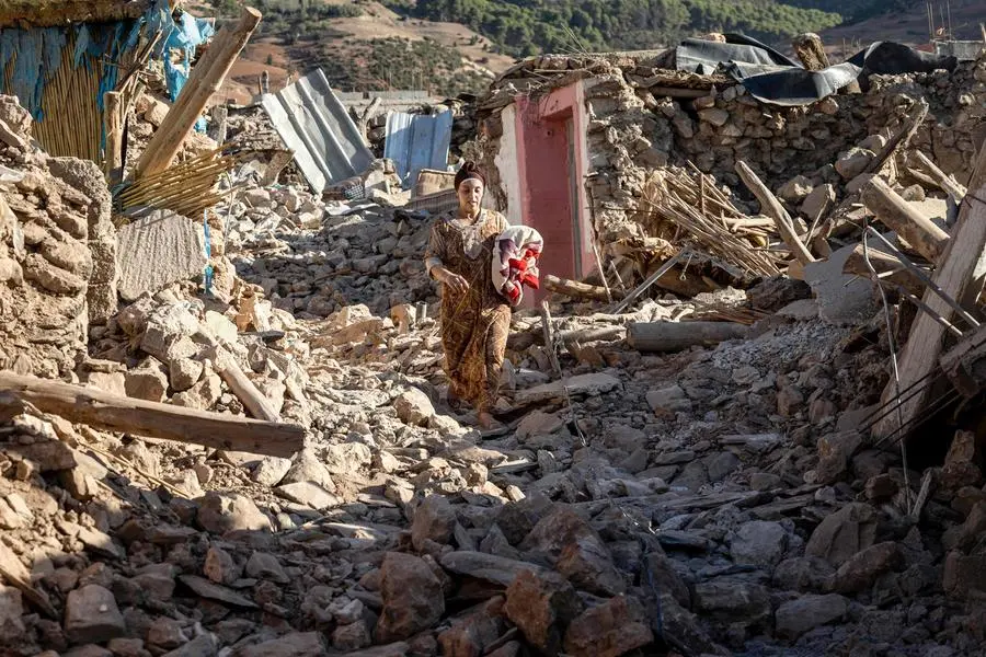 A woman walks past destroyed houses after an earthquake in the mountain village of Tafeghaghte, southwest of the city of Marrakesh, on September 9, 2023. Morocco\\'s deadliest earthquake in decades has killed more than 1,300 people, authorities said on September 9, as troops and emergency services scrambled to reach remote mountain villages where casualties are still feared trapped. (Photo by FADEL SENNA / AFP) , Agence France-Presse (AFP)/AFP