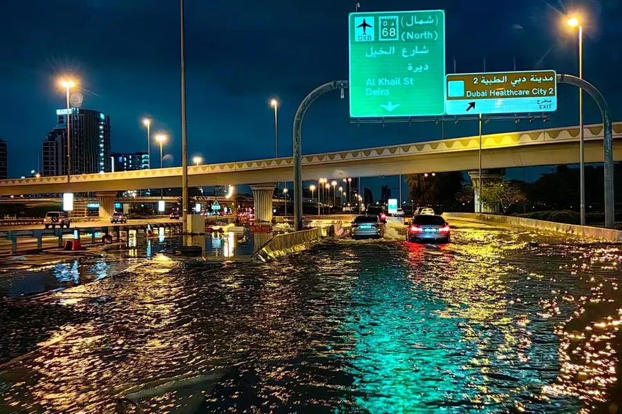 Motorisits drive along a flooded street following heavy rains in Dubai early on April 17, 2024. - Dubai, the Middle East's financial centre, has been paralysed by the torrential rain that caused floods across the UAE and Bahrain and left 18 dead in Oman on April 14 and 15. (Photo by Giuseppe CACACE / AFP)