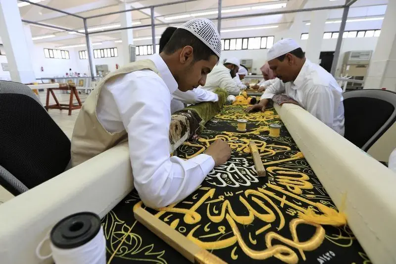 Workers embroider the Kiswa, a silk cloth covering the Holy Kaaba, at a factory in the holy city of Mecca March 13, 2014. The Kiswa of the Kaaba, Islam\\'s holiest site, is 14m high, to match the height of the Kaaba, and 47m wide, enough to cover the four sides of the Kaaba. It is removed every year and replaced with a new one ahead of the annual Haj pilgrimage. REUTERS/Mohamed Al Hwaity , Mohamed Al Hwaity 