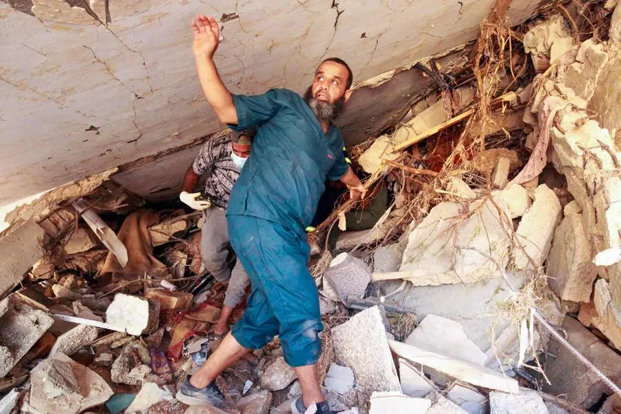 People search in the rubble of a building in a flash flood-damaged area in Derna on September 14, 2023. A global aid effort for Libya gathered pace on September 14 after a tsunami-sized flash flood killed at least 4,000 people, with thousands more missing, a death toll the UN blamed in part on the legacy of years of war and chaos. (Photo by Abdullah DOMA / AFP) , Agence France-Presse (AFP)/AFP