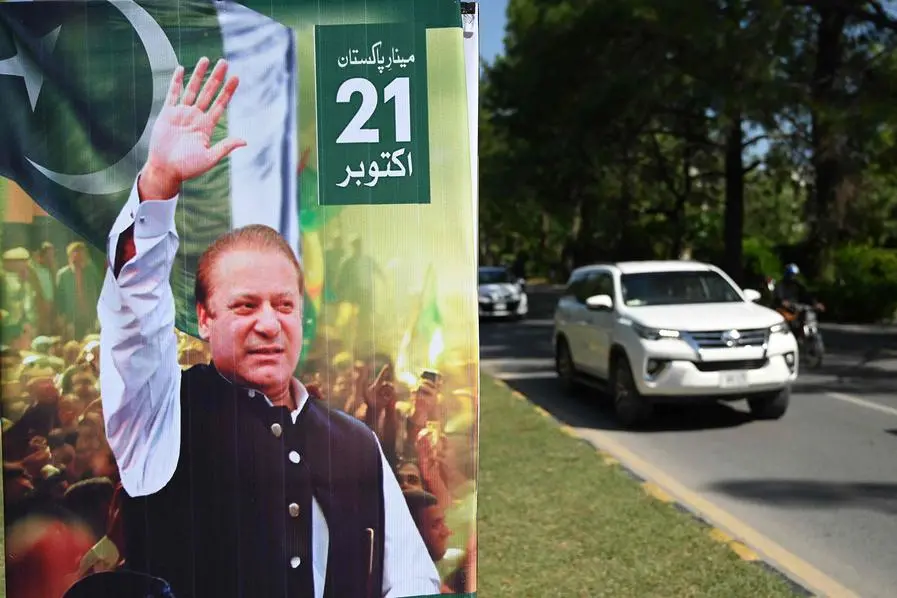 A car drives past a welcoming poster of Pakistan\\'s former prime minister Nawaz Sharif along a street in Islamabad on October 19, 2023, ahead of his return to Pakistan. A Pakistan court granted bail on October 19 to exiled former prime minister and graft convict Nawaz Sharif, removing the threat of arrest when he returns to the country this weekend, his lawyer said. After nearly four years in self-imposed medical exile in the United Kingdom, Sharif is hoping to lead his Pakistan Muslim League-Nawaz (PML-N) party through elections scheduled for January 2024. (Photo by Aamir QURESHI / AFP) , Agence France-Presse (AFP)/AFP