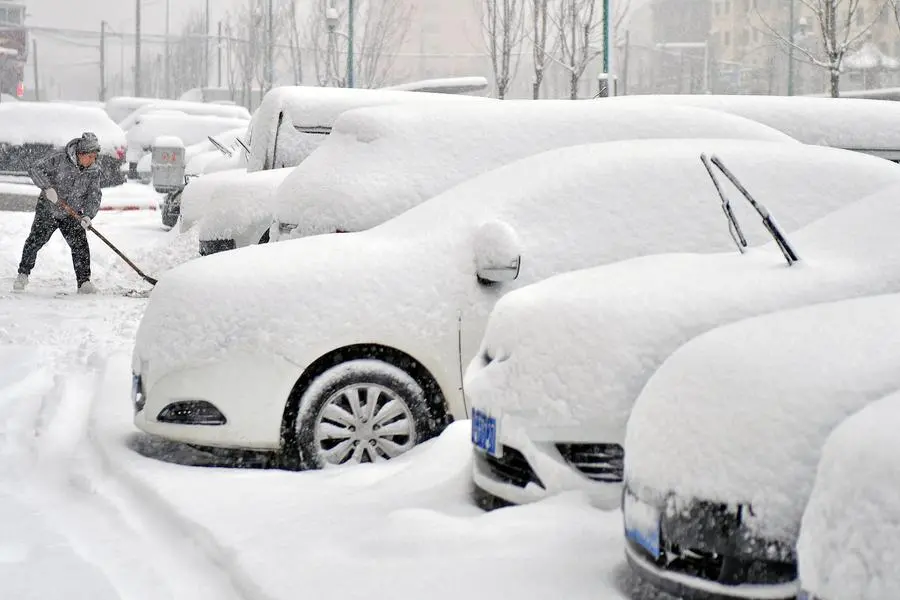 A man clears snow from a road amid heavy snowfall in Yantai, Shandong province, China December 20, 2023. China Daily via REUTERS