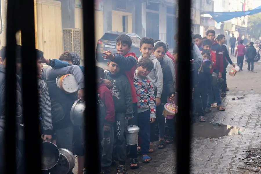 Palestinian children queue to receive food cooked by a charity kitchen, amid shortages in food supplies, as the conflict between Israel and Hamas continues, in Rafah in the southern Gaza Strip December 14, 2023. REUTERS/Saleh Salem , Reuters