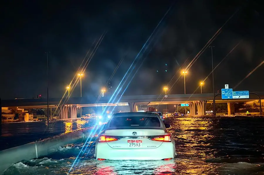 Cars drive in a flooded street following heavy rains in Dubai on April 17, 2024. Dubai, the Middle East's financial centre, has been paralysed by the torrential rain that caused floods across the UAE and Bahrain and left 18 dead in Oman on April 14 and 15. (Photo by Giuseppe CACACE / AFP)