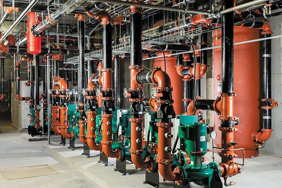 <p>Mechanical room inside a commercial building featuring Victaulic pipe couplings, valves, and elbows</p>\\n