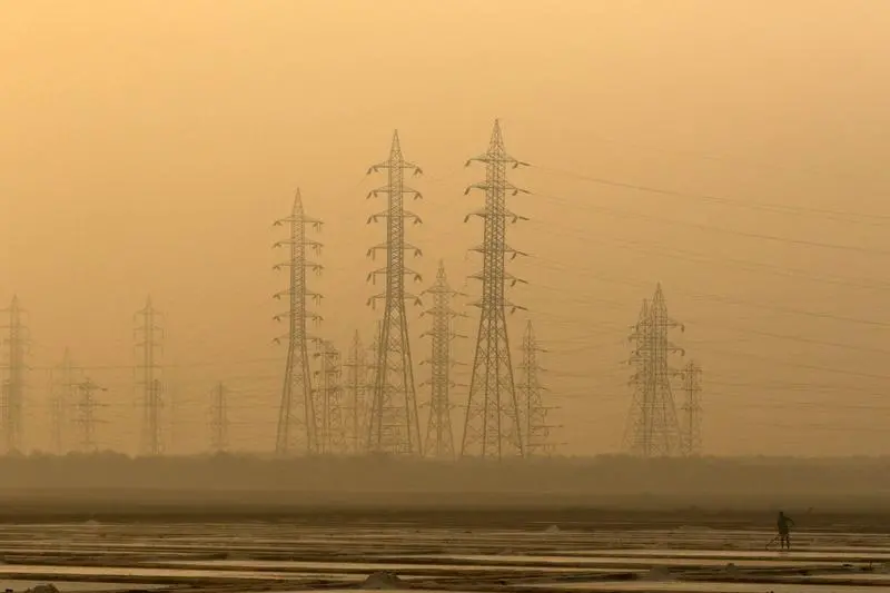 A worker levels a salt pan near electricity pylons in Mumbai, India, January 16, 2017. REUTERS/Shailesh Andrade - RC1D40E96F30 , Reuters Images