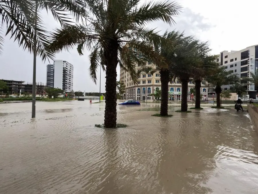 A person rides a motorcycle near a flooded street during a rain storm in Dubai, United Arab Emirates, April 16, 2024. REUTERS/Abdel Hadi Ramahi