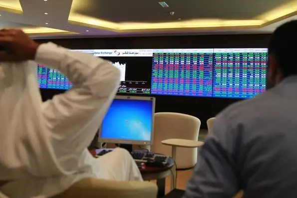 File image used for illustrative purposeTraders speak with each other as they sit behind their desks in front of the Qatar stock exchange board, in Doha February 4, 2014. REUTERS/Mohammed Dabbous , Reuters Images