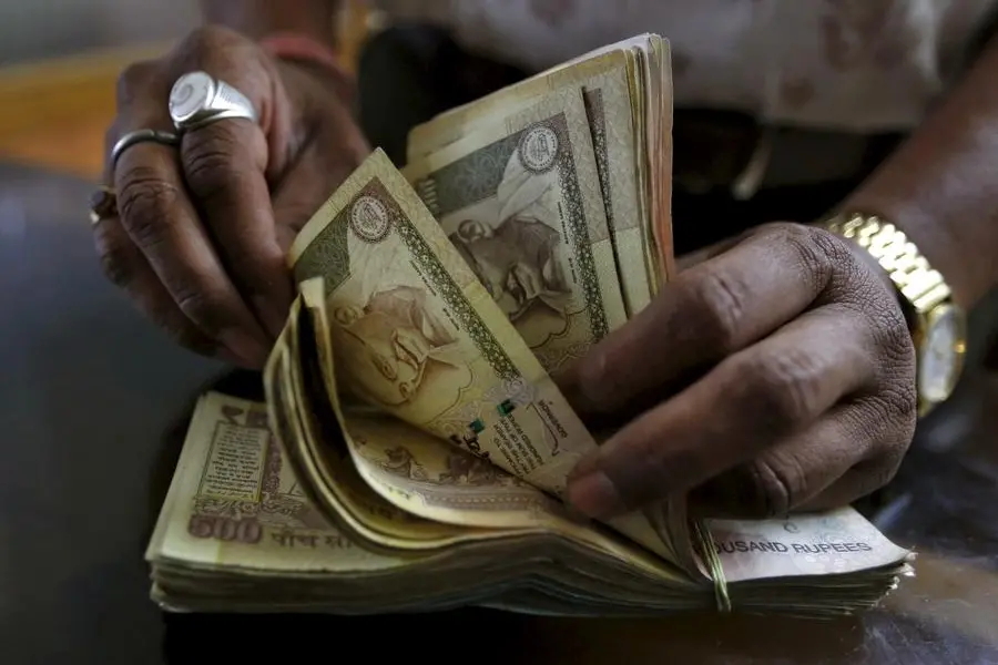 FILE PHOTO: A money lender counts Indian rupee currency notes at his shop in Ahmedabad, in this May 6, 2015 file photo. REUTERS/Amit Dave/Files. , Reuters