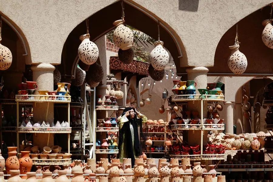 A woman adjusts her headscarf at the Nizwa Souq market on the first day of Eid al-Fitr in Nizwa, Oman, April 22, 2023. REUTERS/Amr Alfiky , Reuters