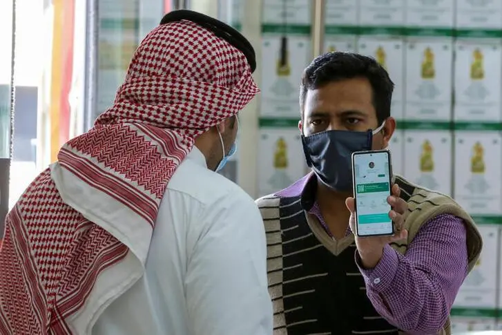 A man displays his details on his mobile phone using the Tawakkalna app, which was launched by Saudi authorities to track people infected with the coronavirus disease (COVID-19), as he enters the Al-Othaim market in Riyadh, Saudi Arabia February 22, 2021. Picture taken February 22, 2021. REUTERS/Ahmed Yosri Image used for illustrative purpose.