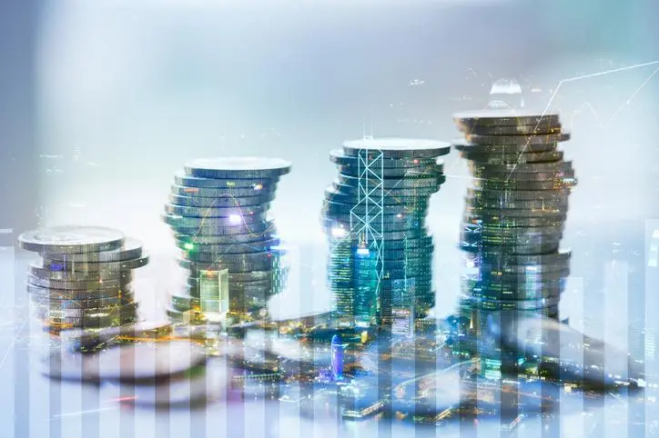 Double exposure of city with graph and stack of coins for finance and business concept , Getty Images/Getty Images