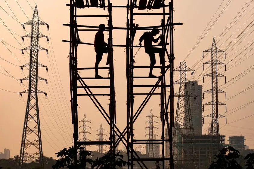 FILE PHOTO: Labourers work next to electricity pylons in Mumbai, India, October 13, 2021. REUTERS/Francis Mascarenhas , Reuters