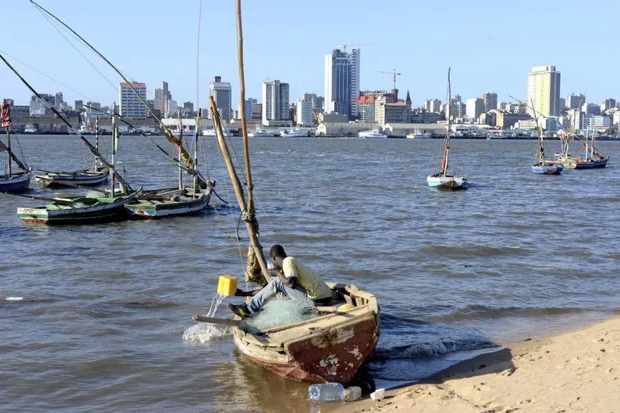 FILE PHOTO: A fisherman cleans his boat beneath Maputo\\'s skyline, in this picture taken August 15, 2015. REUTERS/Grant Lee Neuenburg/File Photo Image used for illustrative purpose. , Reuters