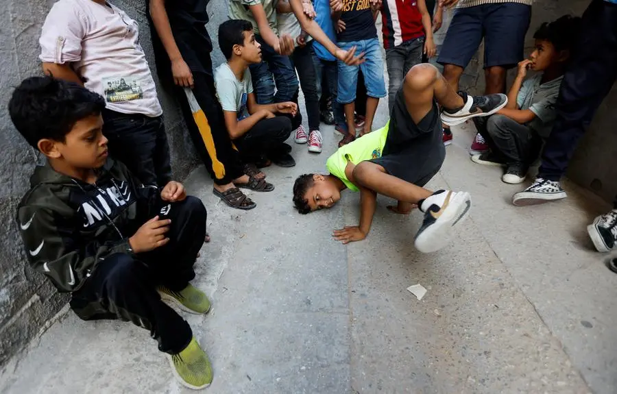 A Palestinian boy Odai Abu Owemer, 11, performs breakdance at a street in Nusseirat refugee camp in central Gaza Strip, October 14, 2022. REUTERS/Ibraheem Abu Mustafa