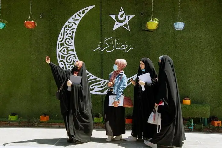 Women take a selfie next to a crescent, ahead of the holy fasting month of Ramadan, in Najaf, Iraq, April 12, 2021. REUTERS/Alaa Al-Marjani , REUTERS