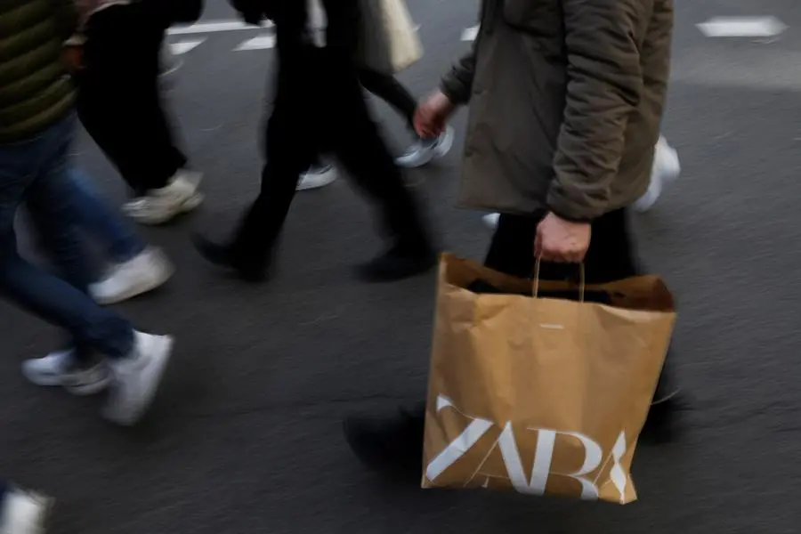 A man walks with a Zara bag in central Madrid, Spain, December 11, 2023. REUTERS/Susana Vera