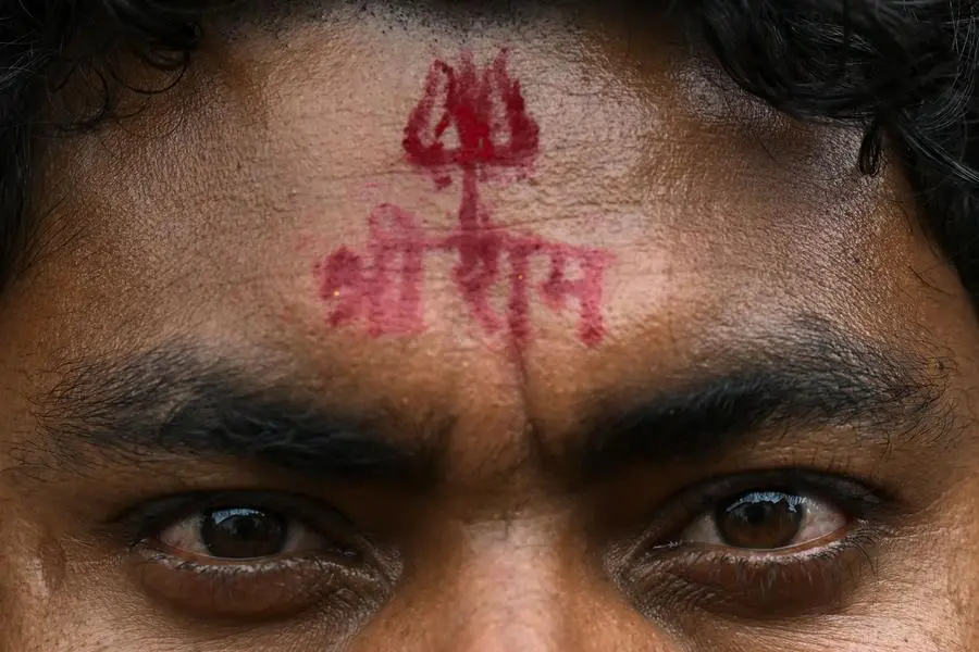 A fairgoer with a vermilion stamp of Hindu god Ram�s name on his forehead looks on at the Ramnami religious movement Bhajan mela - an annual festival of the sect near the Mahanadi river at Jaijaipur in Chhattisgarh on January 21, 2024. While India's great and good gather for the opening of a controversial temple to the Hindu god Ram, some of his most fervent but least privileged adherents gather separately to celebrate the deity -- covered from head to toe in tattoos of his name. (Photo by Indranil MUKHERJEE / AFP)
