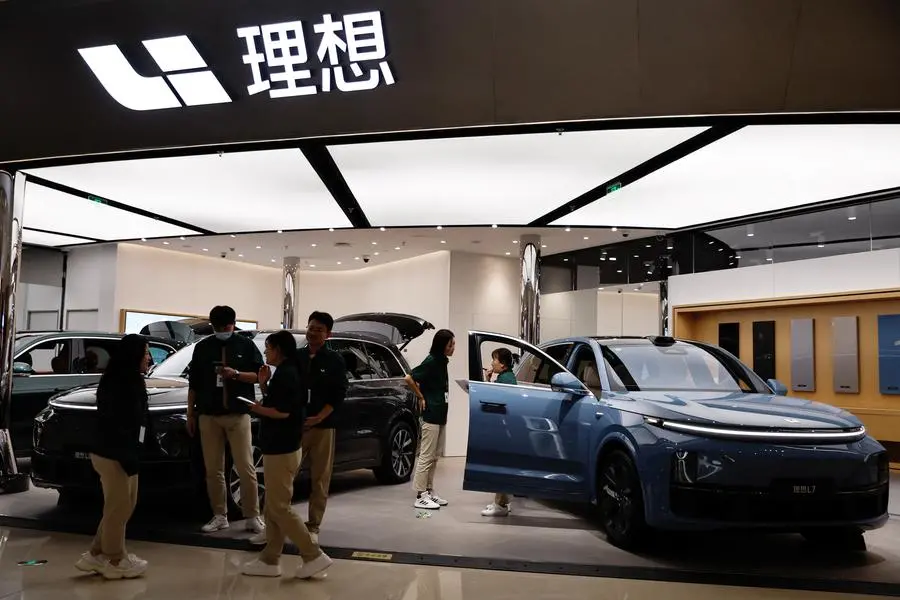 Staff members stand at the booth of Chinese electric vehicle (EV) maker Li Auto, at a shopping mall in Beijing, China November 3, 2023. REUTERS/Tingshu Wang. , Reuters