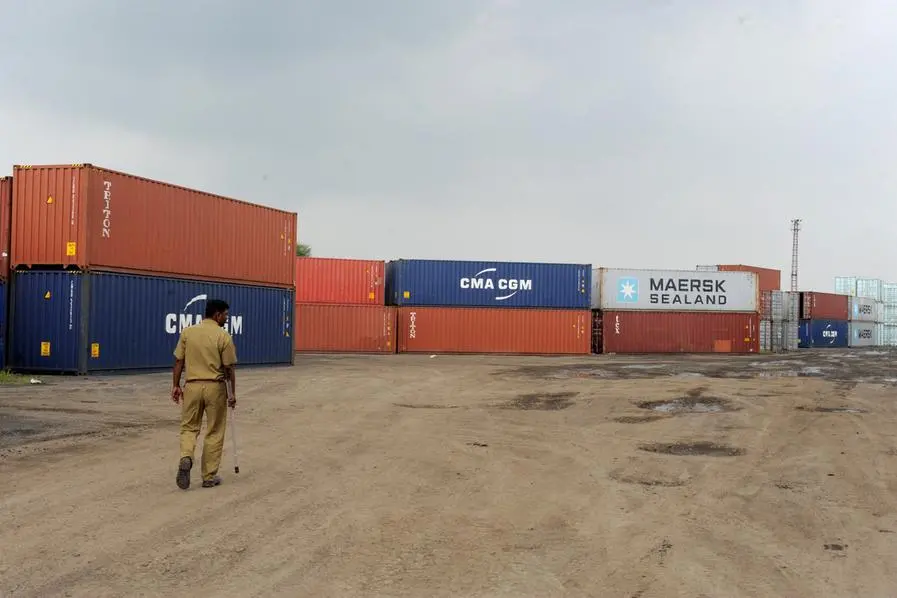 A private security personnel walks between stacked shipping containers at the Inland Container Depot (ICD) at the Thar Dry Port in Sanand, some 30 kms from Ahmedabad on August 19, 2013. AFP PHOTO / Sam PANTHAKY (Photo by SAM PANTHAKY / AFP)