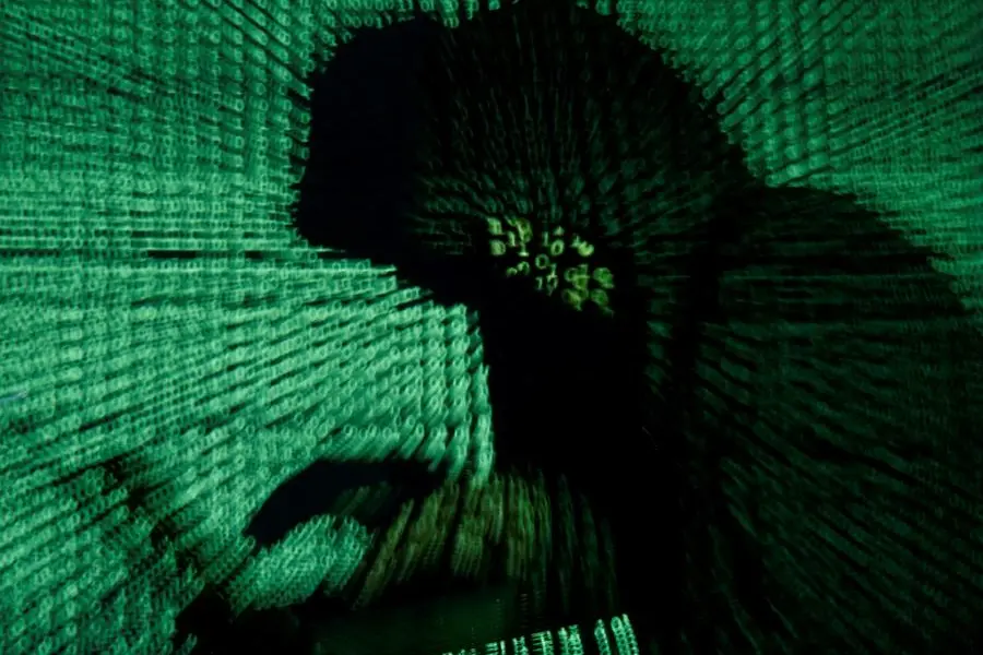 FILE PHOTO: A man holds a laptop computer as cyber code is projected on him in this illustration picture taken on May 13, 2017. REUTERS/Kacper Pempel/Illustration. , Reuters