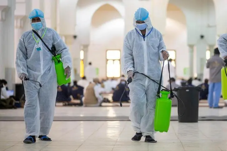 Health workers wearing personal protective equipment (PPE) disinfect the floor as Muslim pilgrims pray inside Namira Mosque in Arafat to mark Haj\\'s most important day, Day of Arafat, during their Haj pilgrimage amid the coronavirus disease (COVID-19) pandemic, outside the holy city of Mecca, Saudi Arabia July 30, 2020. Saudi Ministry of Media/Handout via REUTERS