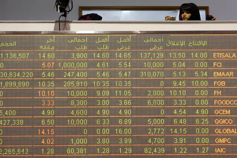 A woman uses her camera near a trading board at the Dubai Stock Exchange in the Dubai World Trade Center. Ahmed Jadallah, Reuters Image for illustrative purposes. , Reuters Images