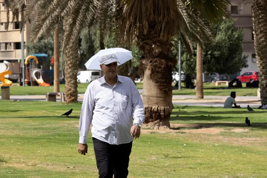A man wearing an umbrella hat protecting him from the sun walks in a garden during afternoon hours in Riyadh, Saudi Arabia, June 28, 2022. REUTERS/Ahmed Yosri , Reuters