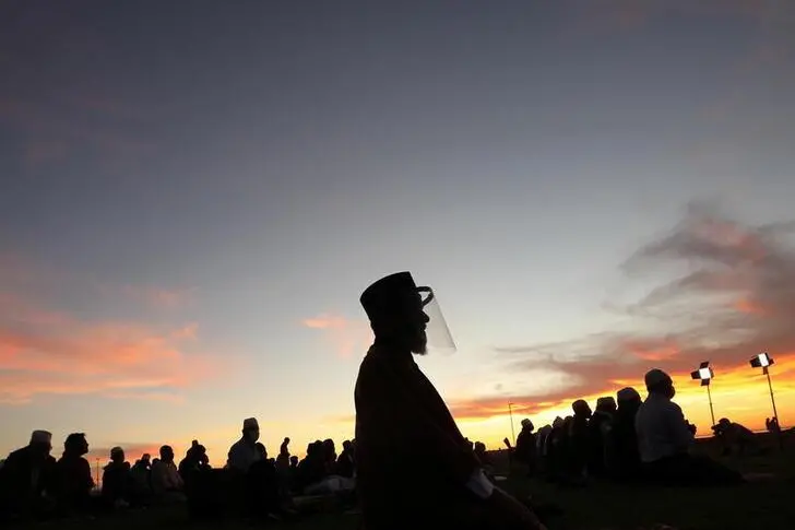 Muslims pray as they await the sighting of the moon that marks the start of the holy month of Ramadan on the Sea Point promenade in Cape Town, South Africa, April 12, 2021. REUTERS/Mike Hutchings , Reuters Images/REUTERS