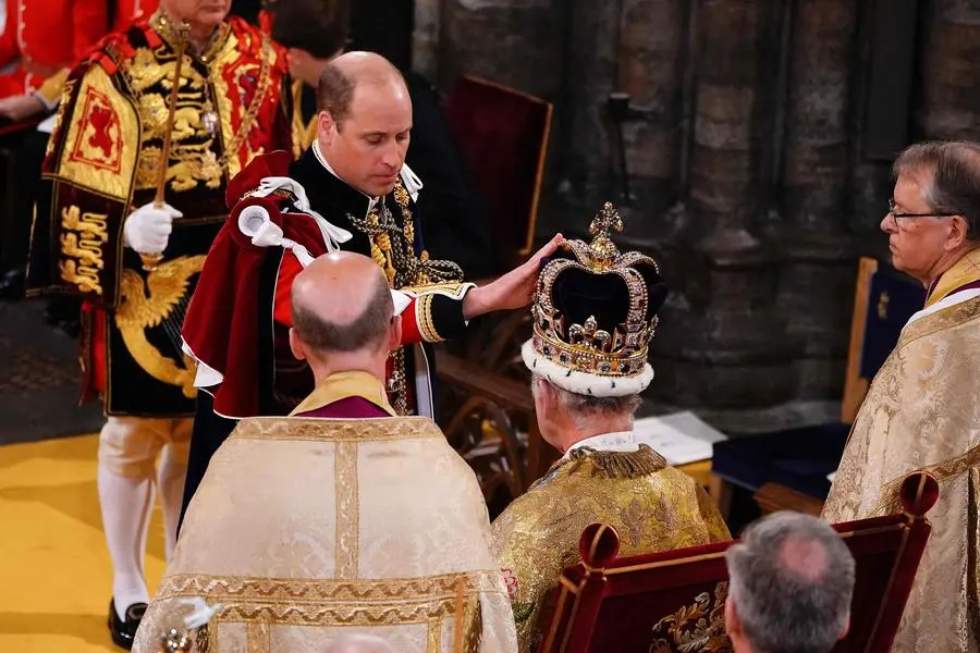 TOPSHOT - Britain's Prince William, Prince of Wales touches St Edward's Crown on the head of his father, Britain's King Charles III, during the King's Coronation Ceremony inside Westminster Abbey in central London on May 6, 2023. - The set-piece coronation is the first in Britain in 70 years, and only the second in history to be televised. Charles will be the 40th reigning monarch to be crowned at the central London church since King William I in 1066. Outside the UK, he is also king of 14 other Commonwealth countries, including Australia, Canada and New Zealand. Camilla, his second wife, will be crowned queen alongside him and be known as Queen Camilla after the ceremony. (Photo by Yui Mok / POOL / AFP)
