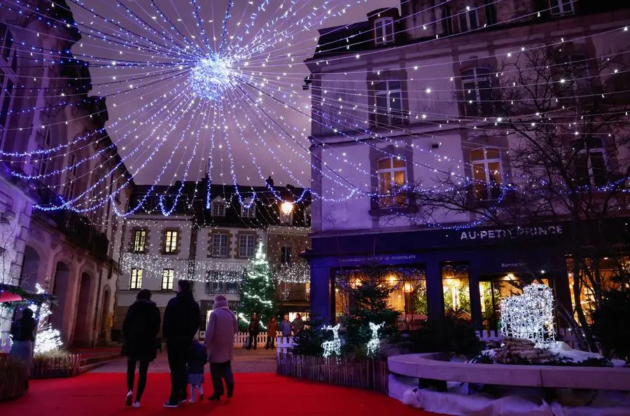 People walk near Christmas decorations, a part of Christmas holiday season, in Auray, France, December 21, 2023. REUTERS/Stephane Mahe