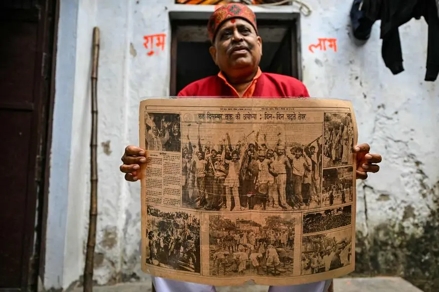 In this photograph taken on December 28, 2023 Santosh Dubey, 56, a member of the mob that demolished the 16th century Babri Masjid, shows a 1992 newspaper article with his picture alongwith fellow members, during an interview with AFP in Ayodhya. For many Indians the opening of a grand new temple in Ayodhya on January 2024 is a long-held dream come true but for Muslims like Mohammed Shahid, the day will evoke only blood-soaked memories. (Photo by Arun SANKAR / AFP) / To go with 'INDIA-RELIGION-POLITICS-UNREST� FOCUS by Abhaya SRIVASTAVA