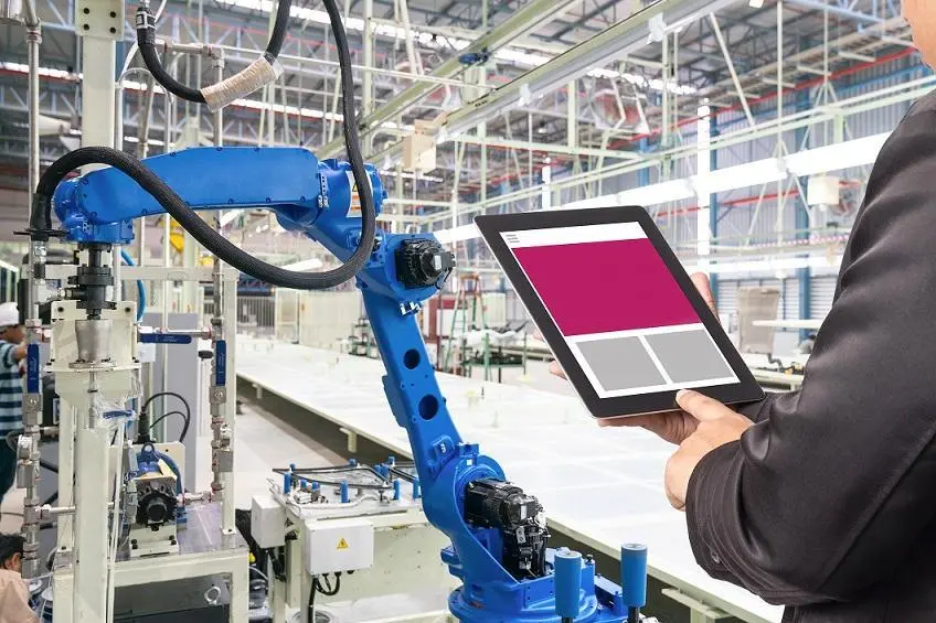 Engineer hand using tablet, heavy automation robot arm machine in smart factory industrial with tablet real time monitoring system application. Industry 4th iot concept. , Getty Images