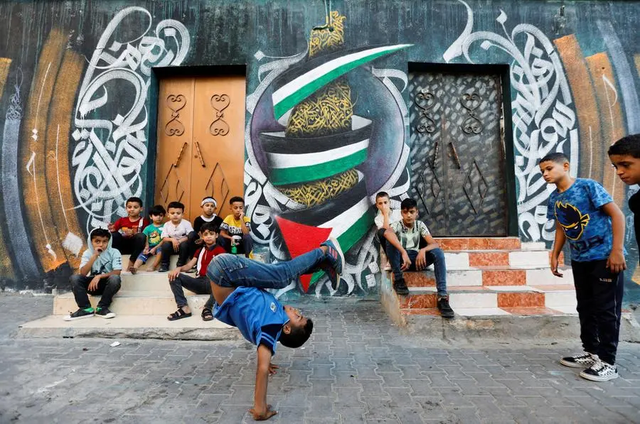 A Palestinian boy performs breakdance at a street in Nusseirat refugee camp in central Gaza Strip, October 14, 2022. REUTERS/Ibraheem Abu Mustafa