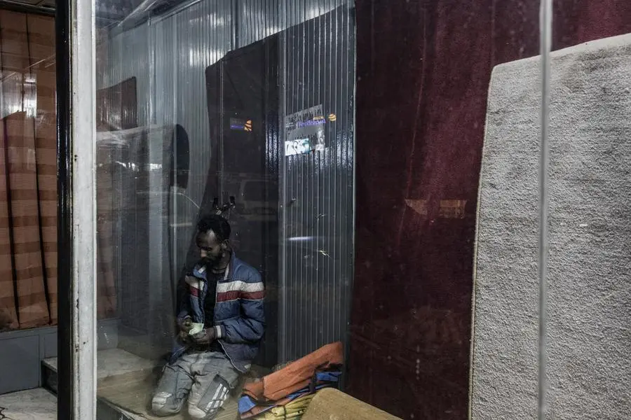 A street hawker counts money at the end of a day work in the Piazza area of Addis Ababa, on June 17, 2021. (Photo by MARCO LONGARI / AFP) Image used for illustrative purpose.