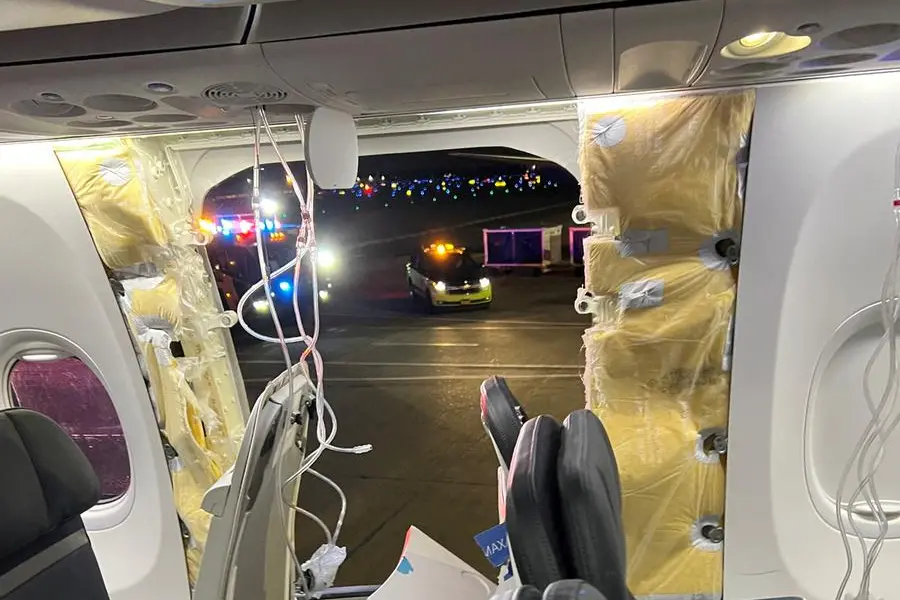 Passenger oxygen masks hang from the roof next to a missing window and a portion of a side wall of an Alaska Airlines Flight 1282, which had been bound for Ontario, California and suffered depressurization soon after departing, in Portland, Oregon, U.S., January 5, 2024 in this picture obtained from social media. Instagram/@strawberrvy via REUTERS