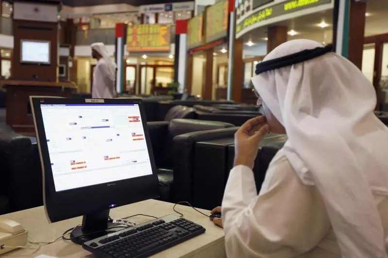 An investor looks at stock exchange information at the Dubai Financial Market. STR New, Reuters , Reuters Images