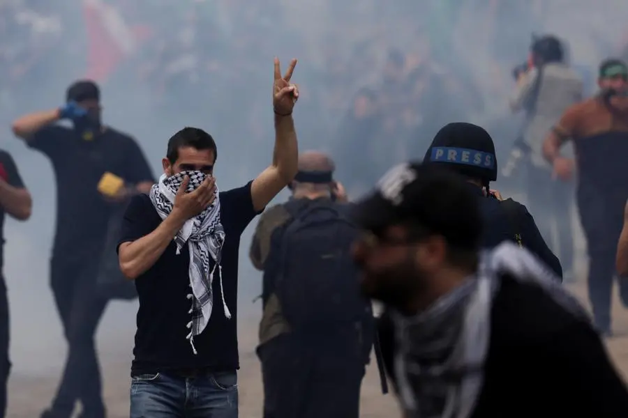 A man gestures among a cloud of tear gas during a protest near the U.S. embassy in Awkar, after hundreds of Palestinians were killed in a blast at Al-Ahli hospital in Gaza that Israeli and Palestinian officials blamed on each other, Lebanon October 18, 2023. REUTERS/Zohra Bensemra , Reuters/REUTERS